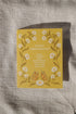 Yellow anniversary card with floral design and text on a textured surface